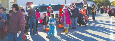 Part of the crowd for the Halloween Trunk or Treat event along Pine St. in Columbus, line up for candy at each of the vehicles parked along the street. Colorful costumes intermingled with the festive and creative displays for a day of family fun thanks to the Columbus Chamber of Commerce’s organization and resources. Photo by Jacob Spencer