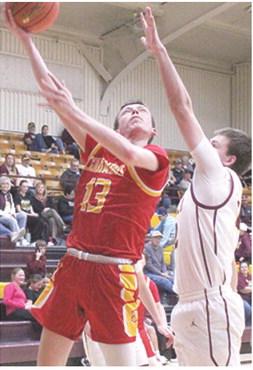 Titan Junior, Carter Woodcock, goes up for two of his team-high, 18 points in the 43-55 loss in Girard, Tuesday. Junior, Ben Cullen defends for the Trojans.