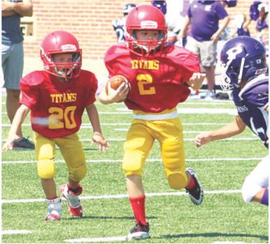 Jaxon Harper eludes a Pittsburg defender on his way to the goal line and into the end zone, Saturday, in the Columbus Mini Titan Third and Fourth Grade win, 26-14, over Pitt Mowen, Saturday at Hutchinson Field in their season opener at Pittsburg. Columbus will host Frontenac tomorrow at Titan Stadium. Kickoff will be at 10 a.m. Frontenac Nelson will be in town for a match up with the Titan Fifth and Sixth Grade Squad. Game time is set for noon.