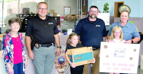 The Baxter Springs Girl Scouts received a helping hand from American Bank as the bank purchased several cases of Girl Scout Cookies which had gone unsold. The girls then delivered the cookies to the Baxter Springs Police Department as a thank-you to the men and women in the department. American Bank vice-president Judy Hill was joined by Girl Scouts Kinley Capps and Sutton Russell as they presented the cookies to Police Chief Brian Henderson, and officers Jimmy Hamilton and Rhanda Andrews.