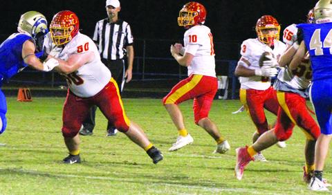 Senior Quarterback, Jack Vilela handed off to junior, Jayden Rodriguez, while seniors, Carter Henry and Jonah Smith make a hole in the line. The Titans took the CNC League win in a 36-0 shutout over the Rams in Riverton, Friday.