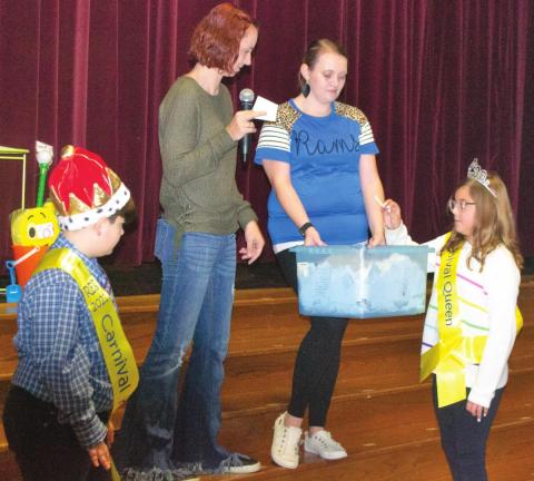 First Grade Teacher Carli Miller stands on stage in Riverton High School’s auditorium with the PTO Carnival King Colton Bebee and Queen Paige Boyes. The students are seen helping her draw tickets for prize money awarded to three of the event’s lucky attendees. Photo by Jacob Spencer.