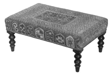 Rugs aren’t just for covering the floor. An antique kilim rug, a style originating in Western Asia, found another life as upholstery for a 20th-century bench. Photo Credit: Thomaston Place Auction Galleries (c) 2025 by Cowles Syndicate Inc.