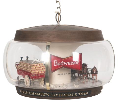 This advertising lamp includes figures of a team of horses pulling a beer cart with drivers, followed by a crowd of Dalmatians. Similar scenes may take place in real life on Budweiser’s promotional tours. The lamp with a moving wagon sold for $625.