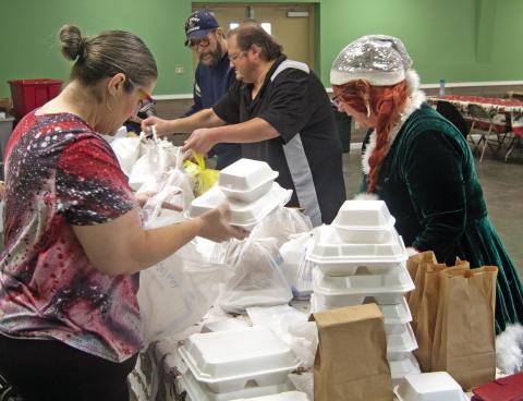 Volunteers prepare Christmas dinners for delivery to those unable to attend the Annual Community dinner at the 4-H building.