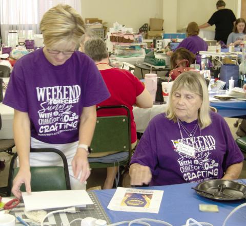 Kristi Fintner and Donna Campbell discuss photo placement on the page of a scrapbook. Everyone seems to be happy to offer advice when someone has a question.