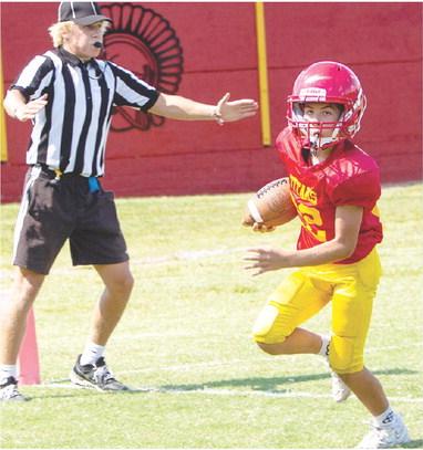 Above: Blaze Bowman crosses the goal line in the Titan Fifth/Sixth Grade, double overtime loss to Frontenac, 20-26, at Titan Stadium, Saturday, in their home opener. Former Titan/Referee, Cade Saporito is there to make the call. Below: Boston Hutto brings down the Frontenac ball carrier. Photos by Kristin Sharp.