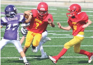 Mini Titan Briggs Johnson gets a block from Bodie Saiz on his way to the end zone for six of the 22 Columbus points scored in the victory over Pittsburg Ryan, 22-0, Saturday, at Hutchinson Field in Pittsburg. Courtesy Photo.