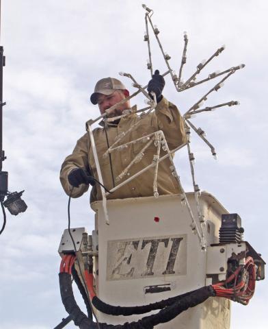 City workers Justin Rogers (pictured), Jared Kite and Kasie England took down the Christmas lights after the holidays. News Report photo by Shawn Churchill.