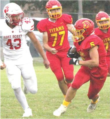 Titan Freshman, Braun Stone, gains yardage in the junior varsity loss to Fort Scott, 0-28, Monday, at Titan Stadium. Stone also highlighted the night for the Titan Defense with a fumble recovery. Junior, Jonah Smith, trails the play with Fort Scott Sophomore, Aiden Ogran.