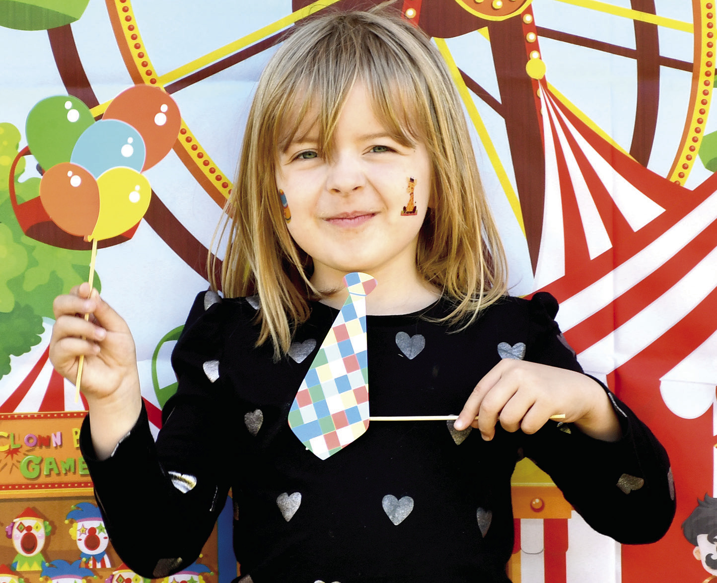 Park elementary kindergarteners celebrated the end of the school year with some last minute carnival fun. Teachers set up and launched a mini carnival at the school including multiple activities. They had a tattoo station, catch the ducks station, boardwalk game, outdoor tic tac toe, ribbon wand fun and popcorn and cotton candy. Meredith Moore shows her tie and balloons in front of the carnival poster. Photo by Tanya Woolsey.