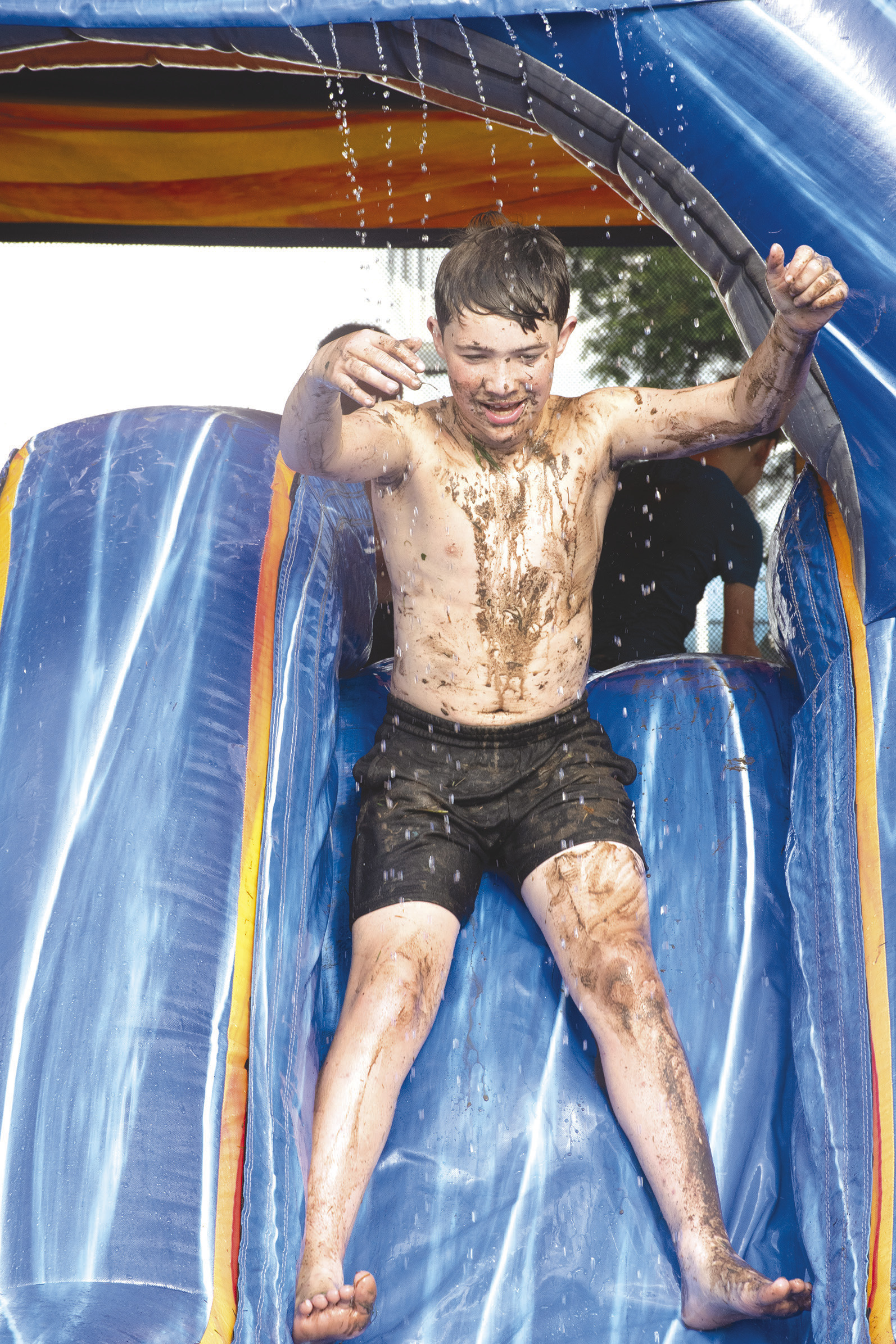 Rainy conditions did not stop youngsters from enjoying the water slide at the annual Freedom Fest sponsored by Columbus Fire Department. Westin Patton was covered in mud as he took his turn down the inflatable set up at Columbus City Park.
