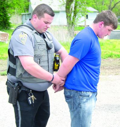 Sheriff’s Chief Deputy Nate Jones puts the handcuffs on actor Skylar Ruddick who was acting as if he was responsible for the wreck.