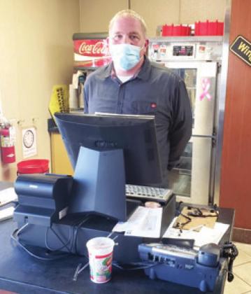 Tyson Coombes, manager at the Baxter Springs Pizza Hut, is behind the register ready to serve the community members hungry for pizza.