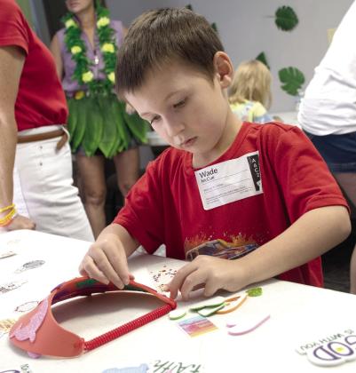 Crafts were a highly anticipated event as part of Connecting Point Church of the Nazarene’s first VBS held the week of July 27. Wade McCue of rural Columbus works to decorate his sun shade.