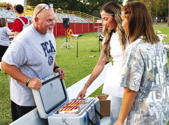 Columbus Fellowship of Christian Athletes leader David Eddington explains to seniors Faith Williams and Tatum Kirk the plan behind the frozen pizzas used in an Ultimate Frisbee Competition as part of the FCA’s Annual kickoff event on Wednesday, September 16.