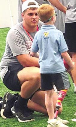 Former Titan and current Gorilla, Kody Schalk visits with a representative of the Shriners Hospitals for Children during activities leading up to the 2022 Kansas Shrine Bowl. Saturday at Carnie Smith Stadium on the campus of Pittsburg State University. Courtesy Photo.