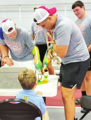 Players in the 2022 Kansas Shrine Bowl participated in challenges using prosthetics and wheelchair races to get a feel for what the patients of Shriners Hospitals for Children go through on a daily basis. Kody Schalk, right, attempts to build a Lego tower with an artificial arm. Players sell program ads and solicit donations with all proceeds going to the network of 22 Shriners Hospitals for Children nationwide. Courtesy Photo.