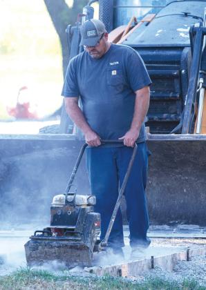 City of Columbus Foreman Justin Rogers works to compact the rock base placed before an asphalt patch was placed on North Kansas Avenue just outside the public works main gate.