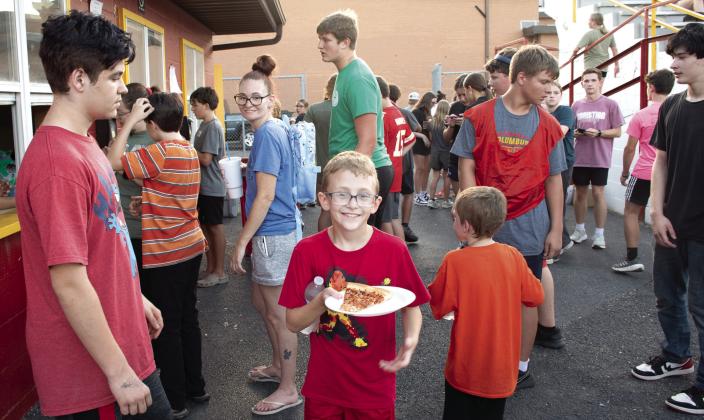 Nothing guarantees a crowd like the offer of free food, the Annual Fellowship of Christian Athletes Kick-Off Event offered free pizza to the more than 100 attendees. An attendee shows off his fresh slice before joining the throng of fellow school kids.