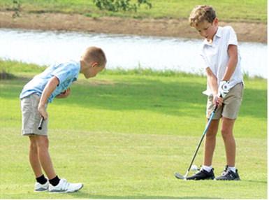 Jack Koons has a watchful eye in Hollis Havercamp’s chip shot during the Thursday junior golf clinic at the Brush Creek Golf Course. Lady Titan Sophomore, Cali Carpino and Titan Senior, Easton Long shared their talents and knowledge with the campers during the multi-week camp.