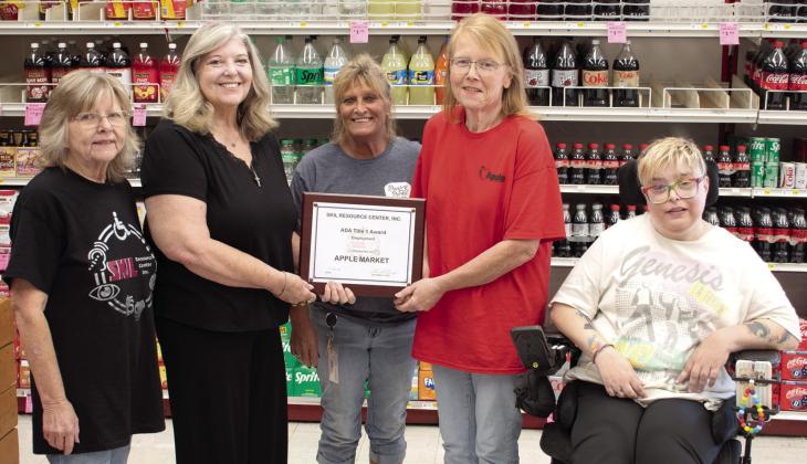 In recognition of their community impact in employing qualified persons with disabilities, SKIL Independent Living Advocate Jeanette Graham, SKIL President and CEO Shari Coatney and Tara Frasier (far right) also a SKIL Independent Living Advocate, present an award to the Columbus Apple Market. Apple Market assistant manager Kristy Jameson and manager Candy Phillips received the award on behalf of the store.