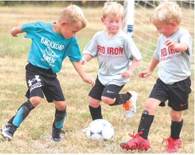 Luca Dainty, Trip Irwin and Reid Irwin are ready to attack the ball during their age three and four soccer game, Saturday, at Eddington Park in Columbus. The Recreation Soccer League has five weeks remaining in their season.