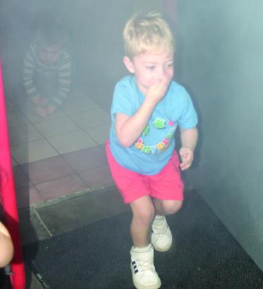 Jack Rapp exits the smoke room as Tiberius Moore crawls to safety. The youngsters were practicing “Stay Low and Go” as part of Fire Prevention Week at Columbus Fire Department.