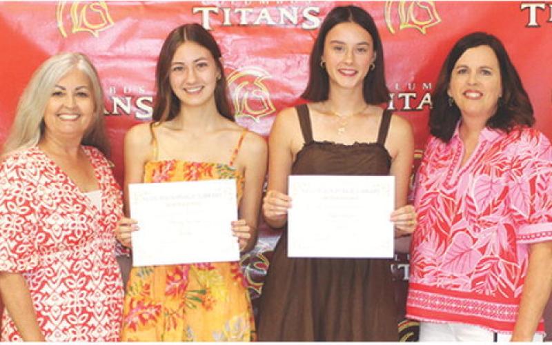 Darcy Garrett and Piper Hayes, seniors, received the Columbus Public Library Scholarship in the amount of $500 each from Shari Napier and Jennifer Thompson, Library Board Members during the Columbus Unified High School Senior Assembly, May 15 at the CUHS Gymnasium.