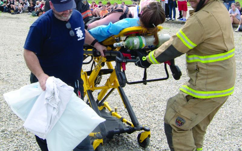 The rough ground on the parking lot made the trip to the ambulance somewhat treacherous as the fire fighters pulled the gurney.