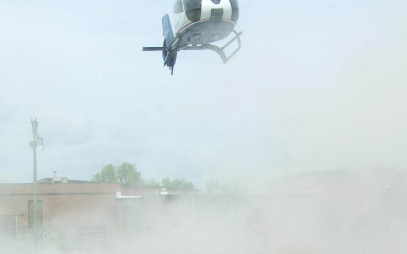 The dust became thick almost hiding the Medflight helicopter as it landed on the parking lot surface.