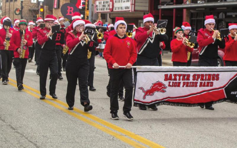 The Baxter Springs Lion Pride Band marches down Military Avenue in the city’s Christmas parade earlier this month. Band Instructor Louis Morgan directs the students as they play “Winter Wonderland” for the crowd. Photo by Jacob Spencer.