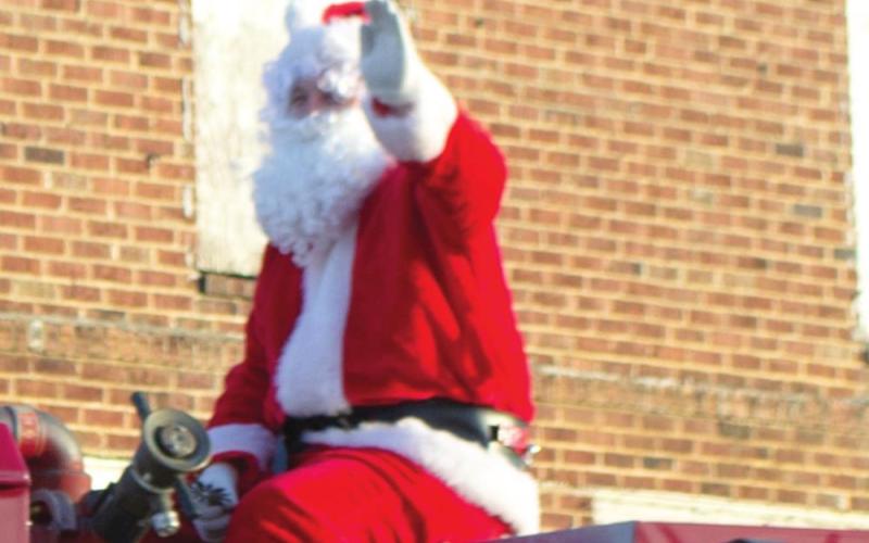 Santa Claus sits atop one of Scammon Fire Department’s fire engines as part of the city’s Christmas parade earlier this month. The magical, cherrycheeked man made several appearances in Cherokee County parades this year. Photo by Jacob Spencer.