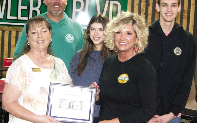 Operators of Bowlers Blvd in Columbus, Chris and Amy Johnson received their first dollar certificate from Chamber board member Sonja Duley during a ribbon cutting for the new member. Also pictured are Manager Allie Smith and Chris and Amy’s son Seth Johnson.