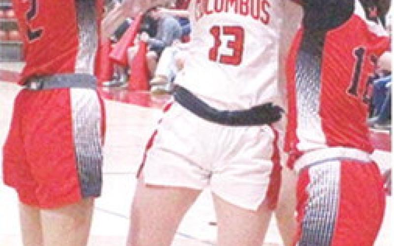 Lady Titan Senior, Trinity Green, goes up for a basket between the outstretched arms of senior, Mya Vestal and junior, Layla Weaver, in the 39-20, Columbus win, Tuesday, at the CUHS Gymnasium.
