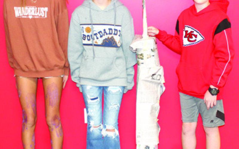 Students in Nicholas Weber’s seventh grade science class used the metric system to build scale models of the North Tower in commemoration of the 911 anniversary. The models were built using newspaper and tape with the requirement that it had to stand alone when completed. Addilyn Wilson, Maddie Duling, Ryker Youngblood show their tower.