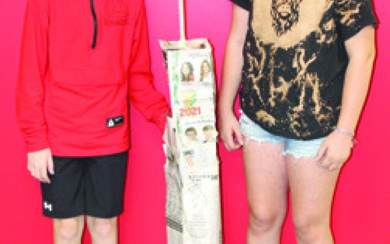 Students in Nicholas Weber’s seventh grade science class used the metric system to build scale models of the North Tower in commemoration of the 911 anniversary. The models were built using newspaper and tape with the requirement that it had to stand alone when completed. Kaden Thiele and Adalynn Hutto with their creation.