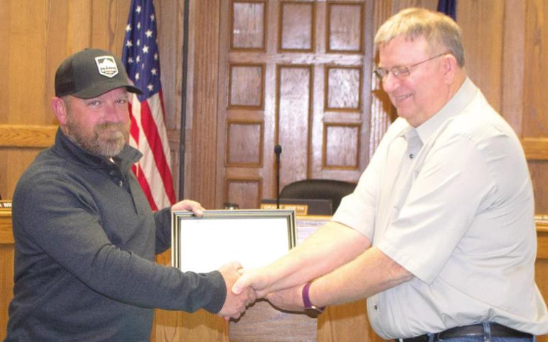 Mayor Grant Spieth presents resigning Columbus City Council Ward 4 Member Nate Long with a certificate of accomplishment at Monday night’s city council meeting. “It’s been good,” Long said, addressing the council. “I appreciate each and every one of you.” Photo by Jacob Spencer