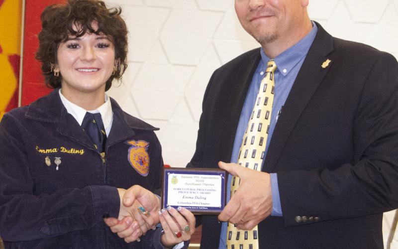Emma Duling received the agricultural proficiency award for her program of buying raw sides of leather, then tooling, painting, staining and stitching the leather to create products that can be sold. KC Youngblood presented the award during the recent Future Farmers of America awards ceremony.