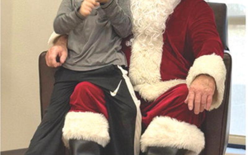 An early visit to Cherokee County by Santa Claus was an opportunity for Jacob Schreiner to share his Christmas wish list. Schreiner and the rest of Suzette Henderson’s Kindergarten class at Park traveled to American Bank Wednesday to meet Jolly St. Nick. Courtesy photo.