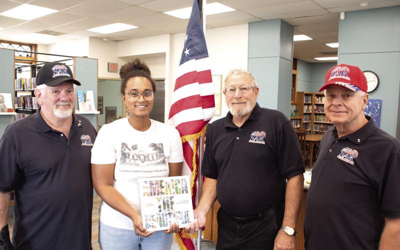 Members of the Little Balkans Chapter of the Sons of the American Revolution presented the Columbus Public Library with a new flag and a book about America. John Gilpin, Lauren Dainty, Rick Parmele and Martin Dupslaff were on hand for the presentation.
