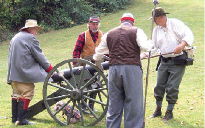 Pat Outa, Matt Wright, Bill Bader, and Wayne Pease from the Confederate army are completing a drill in loading the cannon. The cannon was fired during the Civil War re-enactment held during the Baxter Springs Fall Festival held Saturday and Sunday. Photo by Amber Helwig.