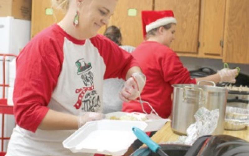 Amanda Stone and Erica Oehme dish up the Christ- mas meal