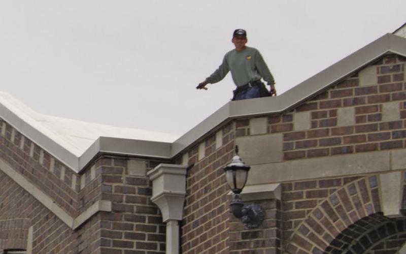 Workers were atop the Baxter Springs First Baptist Church on Sunday afternoon covering the open area’s with tarps before anymore rain could get into the building.