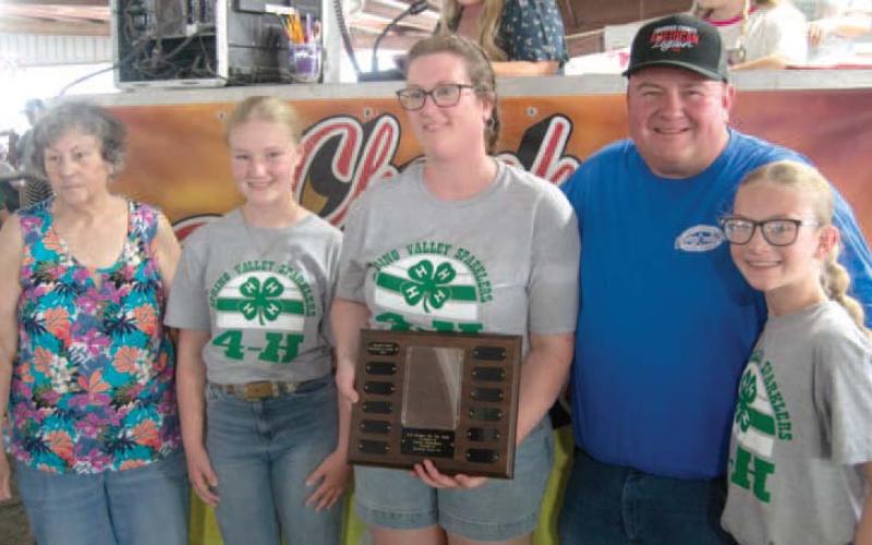 Nancy Herrenbruck presented the Holmes Family with the 4-H Family of the Year award. Ryleigh, Laura, David and Reagan Holmes accepted the award.