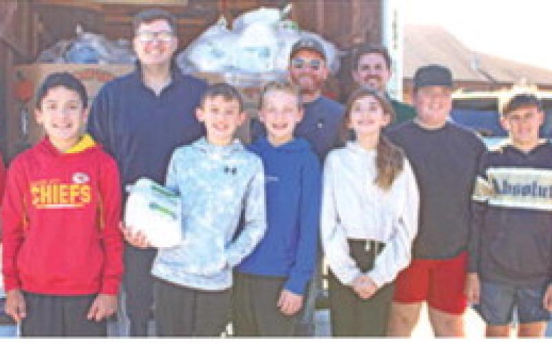 Jake LaTurner, Jake Conard and Daniel Koucky were joined by Columbus sixth graders to unload turkeys to be used in the Thanksgiving baskets.