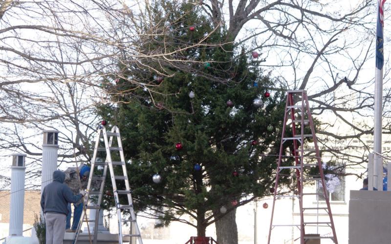 Columbus Lions Club members harvested a tree for the Courthouse on Sunday afternoon. With help from the Fire Department, the tree was raised in place and decorated. Lights were strung on the tree by Lions Club members.