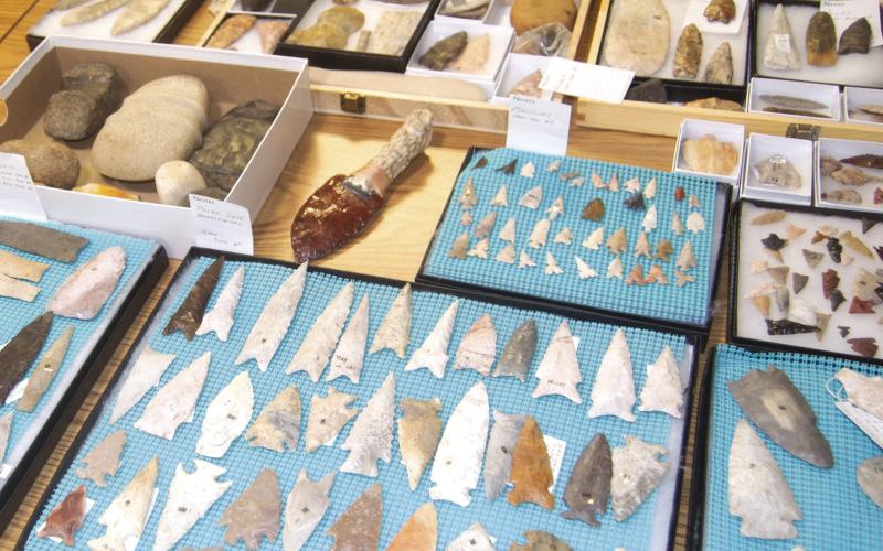 Finding traces of human history is always an exciting experience. There’s something extra special, about discovering a site or artifact. Janet Hand has spent hours in the fields and along creek beds looking at the ground for prehistoric tools or Native American arrowheads. (Above) is a portion of her collection including both tools and hunting items. (At right) Janet holds the head of a tomahawk which was found on the farm of Floyd Lyerla near Crestline in Cherokee County.