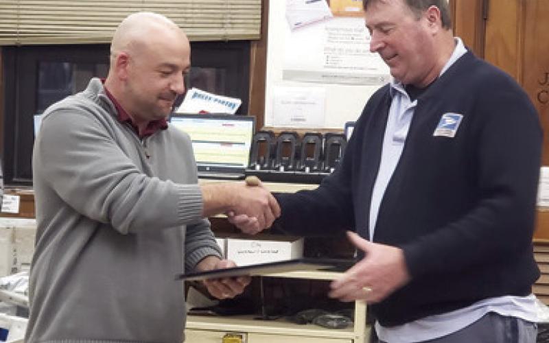 Columbus Post Master Tyler Speer presented long time postal carrier Patrick Billesbach with a certificate recognizing his years of service and celebrating his retirement. Billesbach has worked in Pittsburg as well as here in Columbus. Billesbach began as a mail clerk before taking a carrier position. Courtesy photo.
