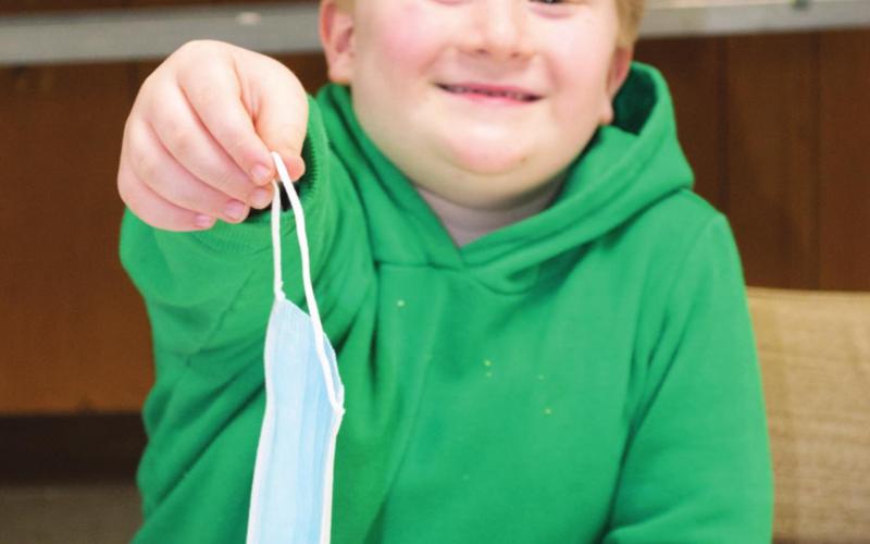Easton Haywood was handing out masks at the goat and sheep meeting on Thursday evening in the 4-H building. The meeting gave 4-H’ers and professional goat and sheep shepherds a chance to discuss problems in the business.